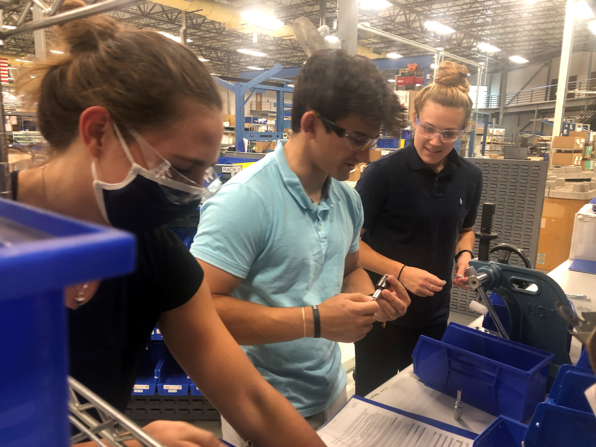 Mack interns, from left, Isabelle Nolan, Hayden Gallo and Nicole McCarvill work on a manufacturing line.