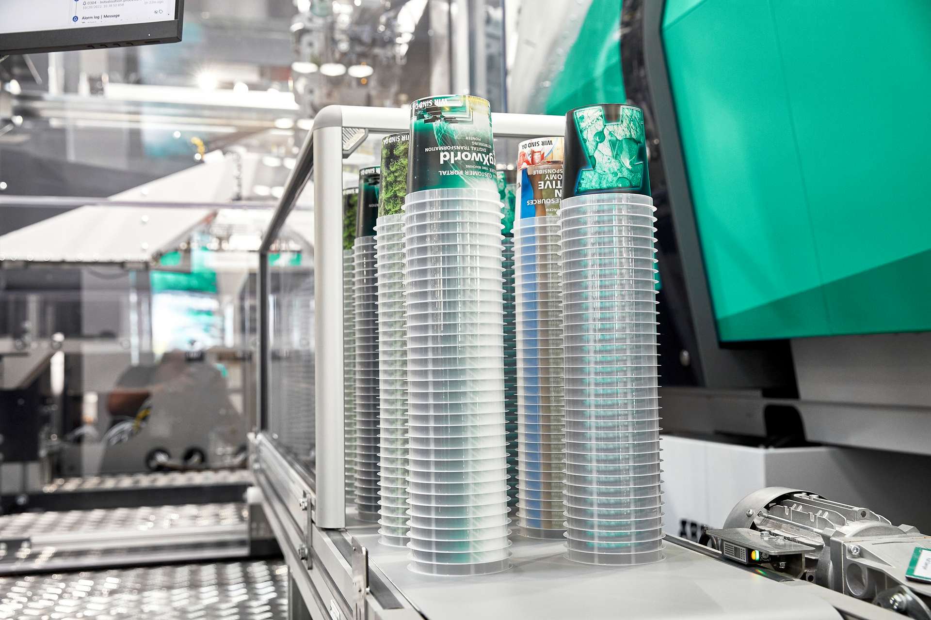 An Arburg work cell with a Brink mold and robot demonstrated injection-compression molding of thin-wall cups at K 2022 and Arburg Anniversary Days.