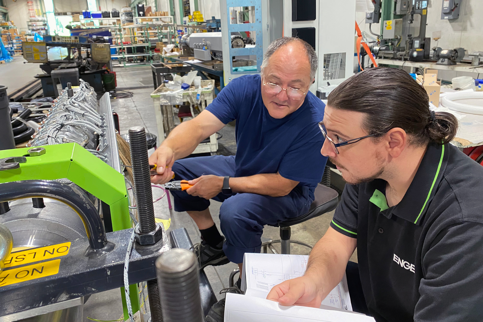 A trainer, left, works with an Engel apprentice.