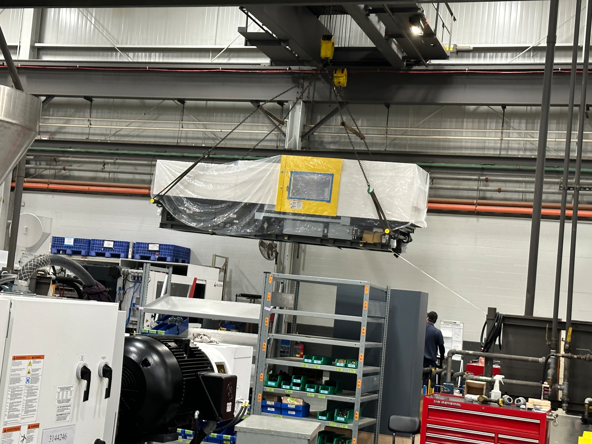 A 60-ton crane moves an injection molding machine at the Batavia, Ohio, facility of Milacron, where dozens of processing machines are currently under construction.