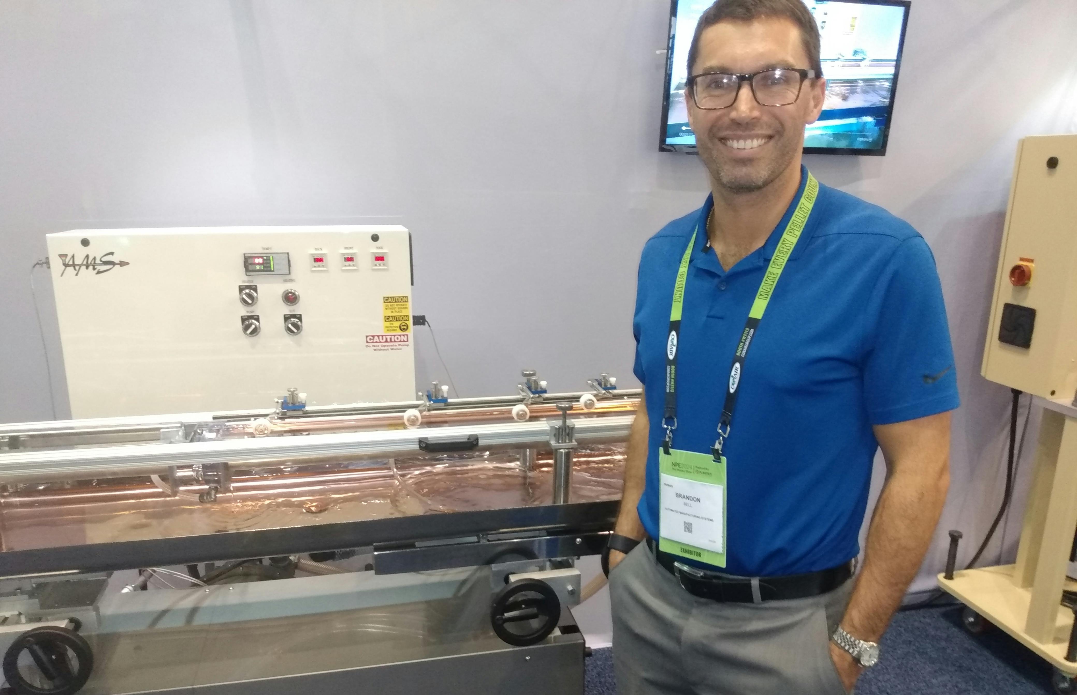 Brandon Bell, co-owner of Automated Manufacturing Systems, shows off the GenFlow, a cooling system he and his father, Rick Bell, designed and patented.