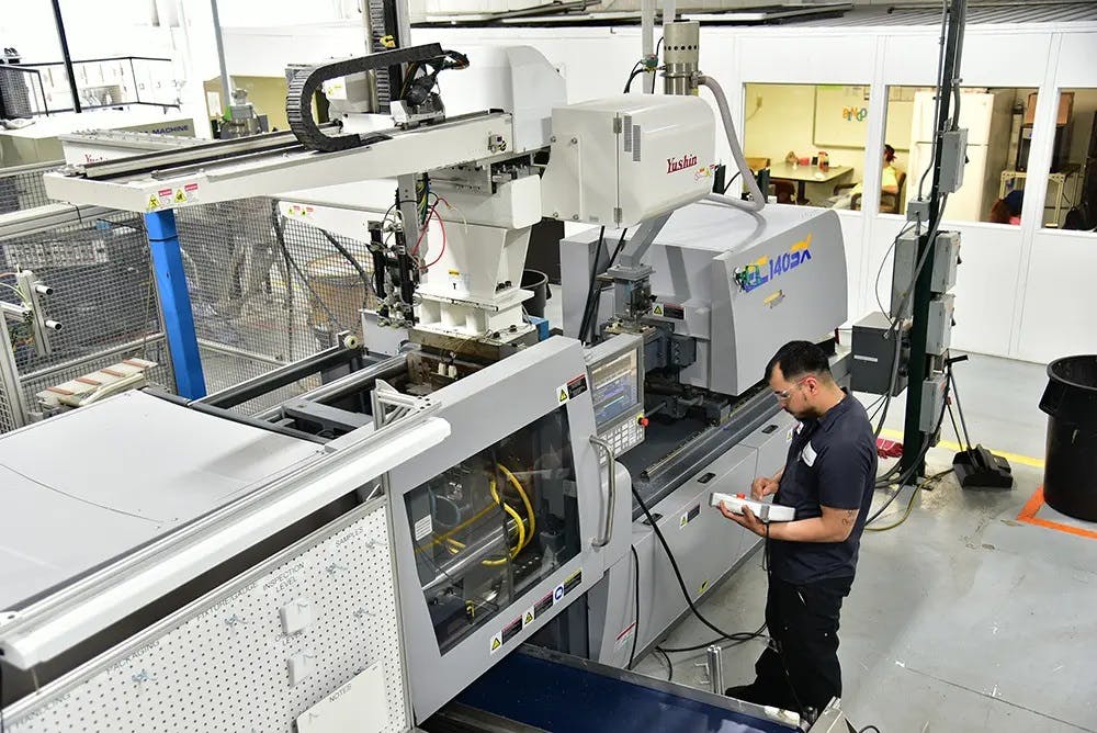 Amid hiring challenges, molders have invested in automation. Among them is Rockford, Ill., Pyramid Plastics, where a Yushin robot is shown stationed above a press.