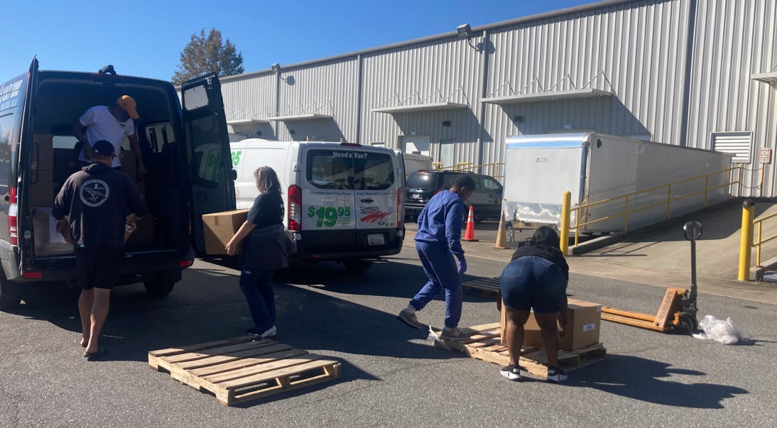 People load items outside Hasco's warehouse in Fletcher, N.C., where the company has worked with a missionary group to collect and distribute supplies for people trying to recover from the destruction wrought by Hurricane Helene.