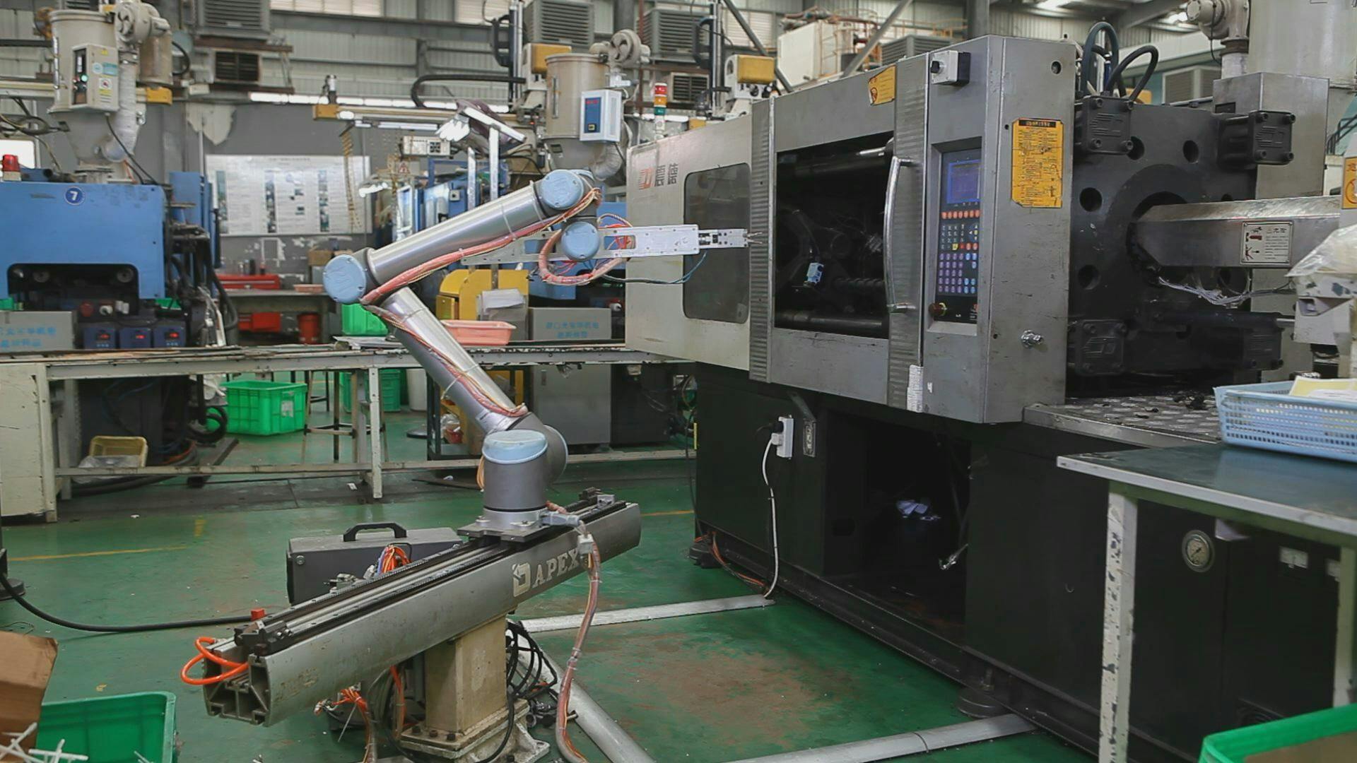 A Universal Robots cobot on a slider tends an injection molding machine at Xiamen Runner Industrial Corp. in China.