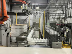This automatic palletizer is handling 64-ounce bottles on 44-inch by 56-inch pallets. This automatic palletizer is handling 64-ounce bottles on 44-inch by 56-inch pallets.