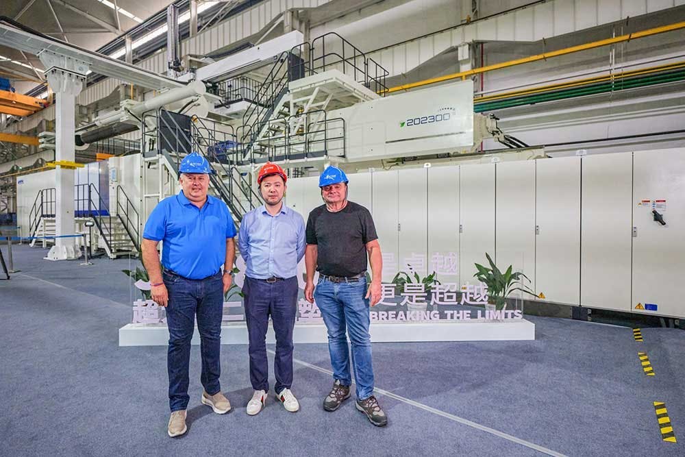 Workers pose with the JU88000 V, an 8,800-ton injection molding machine Haitian delivered to French molder Belli SAS.