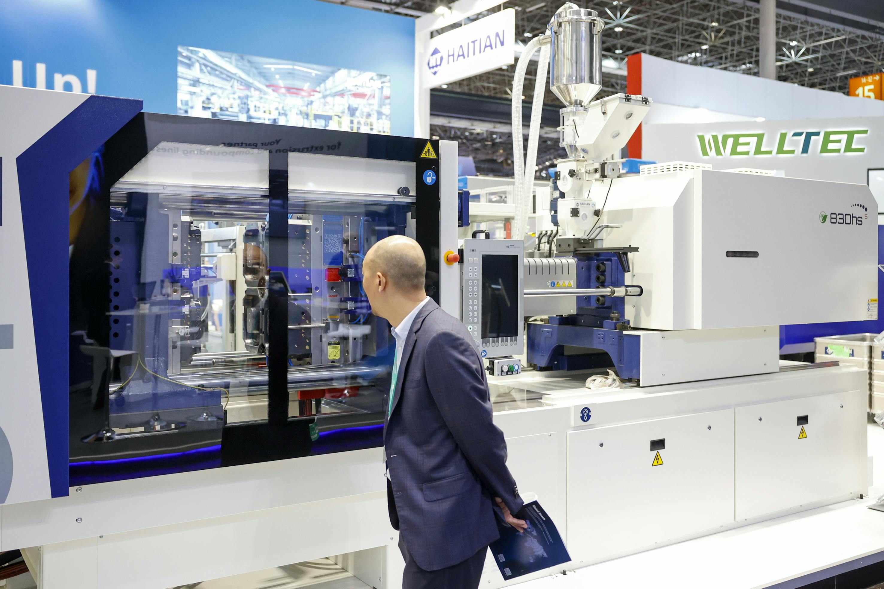 A visitor checks out an injection molding machine at K 2025.