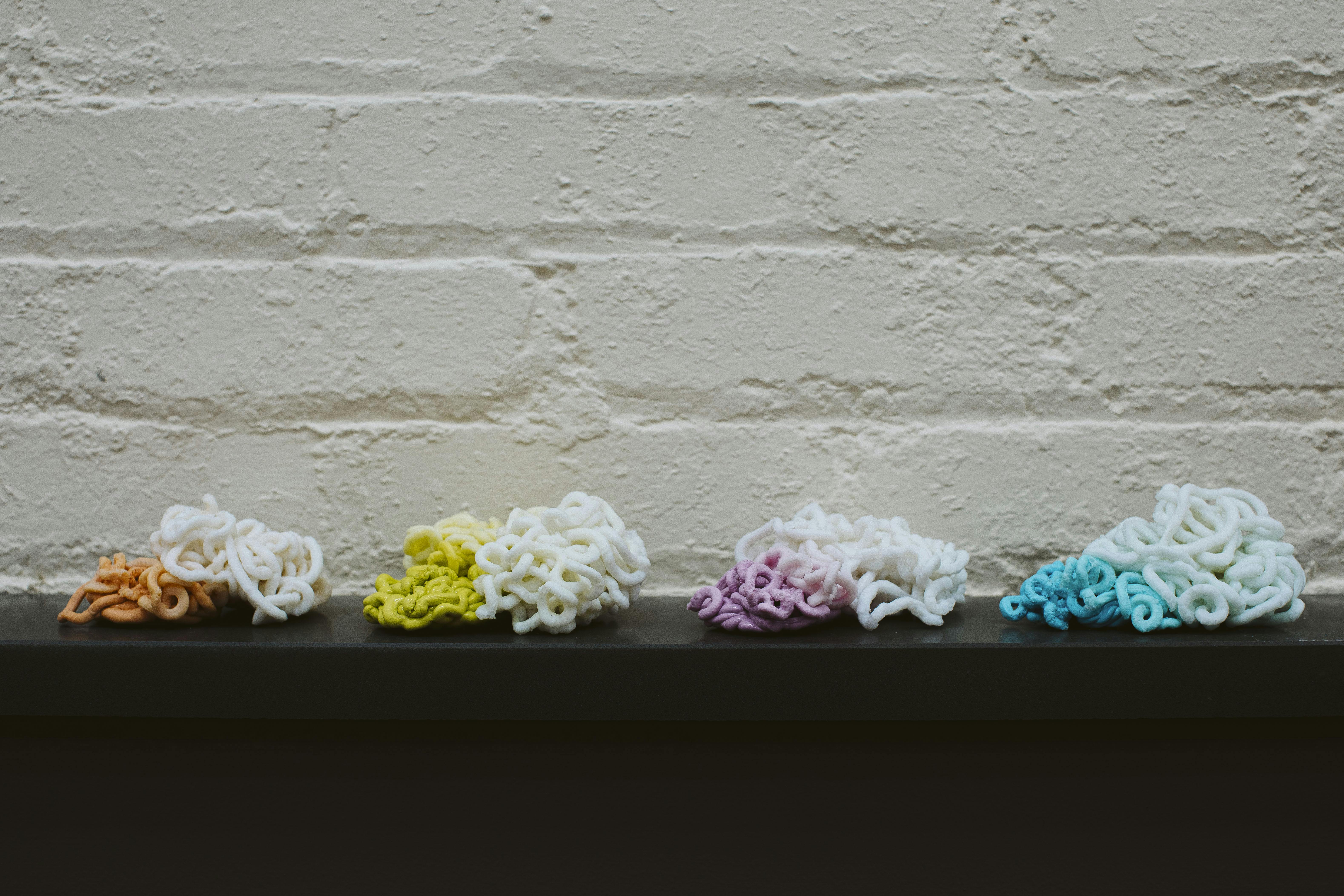 Shuman Plastics used E4 to purge an injection molding machine of colored plastics, producing these piles of plastics, chronicling the process from the beginning, starting with a colorant and ending when that colorant was completely drained from the system.