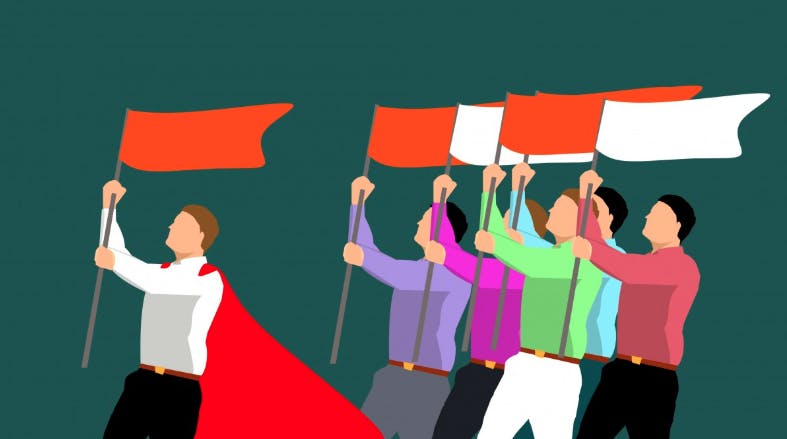 To represent leadership in a company, a person carrying a red flag leads a group of other people with flags.