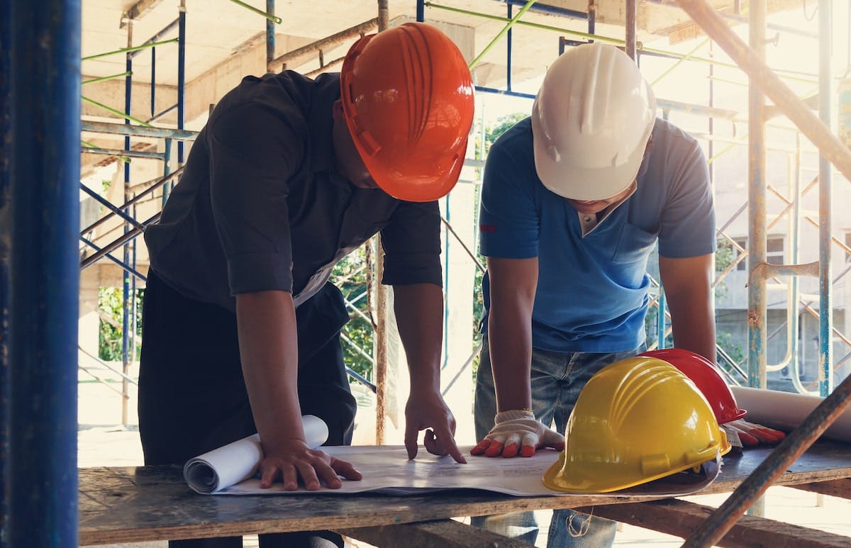 66fdc9bc3cabd9ec17a6af2a Builders20looking20at20plansmin