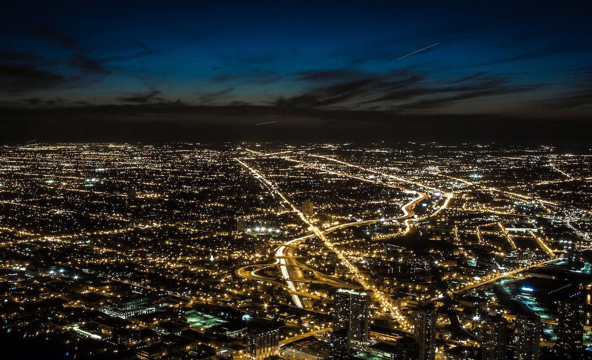 Light pollution shown in aerial nighttime view of a city and suburbs