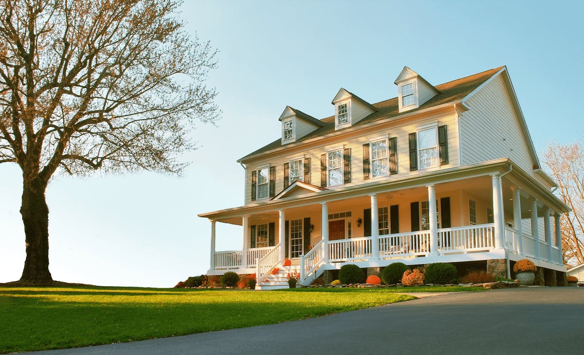 Traditional home exterior with a porch, pitched roof, and window shutters