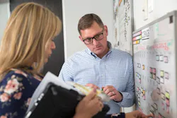 Thrive Home Builders' Operations Vp Bill Rectanus Consults At The Whiteboard With Deia Vonfeldt, Construction Operations Manager Thrive Home Builders' Operations Vp Bill Rectanus Consults At The Whiteboard With Deia Vonfeldt, Construction Operations Manager