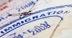 Blue immigration stamp on document Blue immigration stamp on document