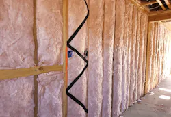 Fiberglass batts installed to insulate a home wall cavity Fiberglass batts installed to insulate a home wall cavity