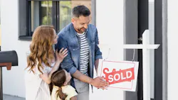 A family puts a 'sold' sign over a 'for sale' sign in front of a new home A family puts a 'sold' sign over a 'for sale' sign in front of a new home
