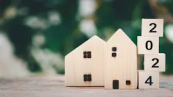 A wooden model home with blocks spelling out '2024' displayed next to it A wooden model home with blocks spelling out '2024' displayed next to it