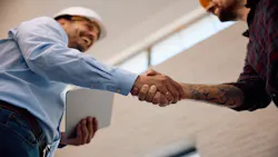 A contractor shakes hands with a client. A contractor shakes hands with a client.