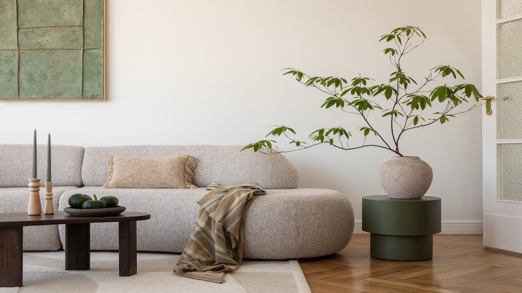 Modern living room grounded in nature with neutral hues and plant life.
