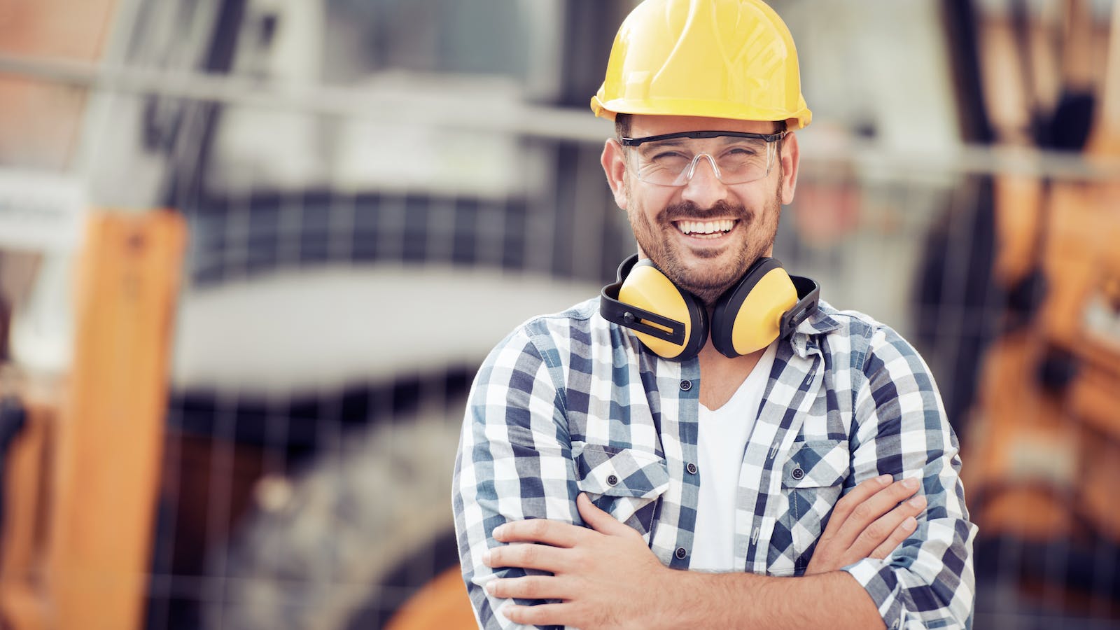 A construction worker in a yellow hard hat on at a jobsite