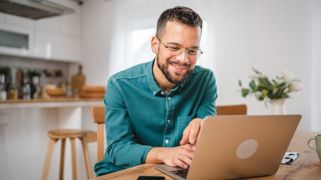 A kitchen designer using a laptop at his kitchen table