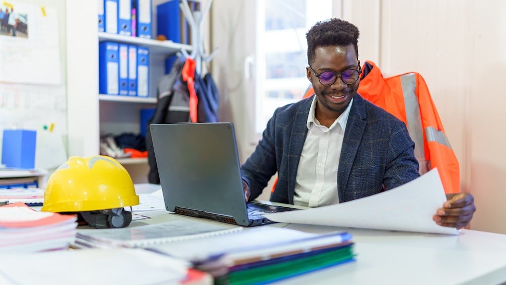 A construction business owner looks over notes at his desk.