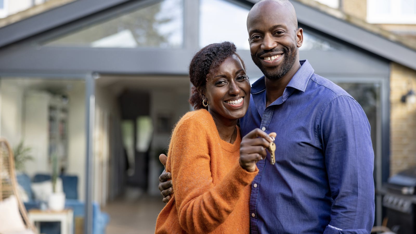 Black homebuyer couple hold keys to their new home