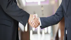 Two businessmen shaking hands represents business deal between Rocket Companies and Redfin Two businessmen shaking hands represents business deal between Rocket Companies and Redfin