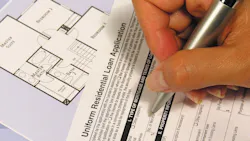 A person filling out a mortgage application as the rate of mortgage applications declines. A person filling out a mortgage application as the rate of mortgage applications declines.