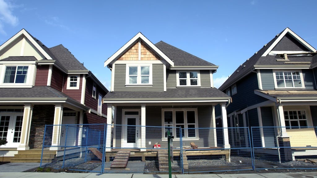 A row of new single-family homes nearing completion as new-home inventory reaches new highs.