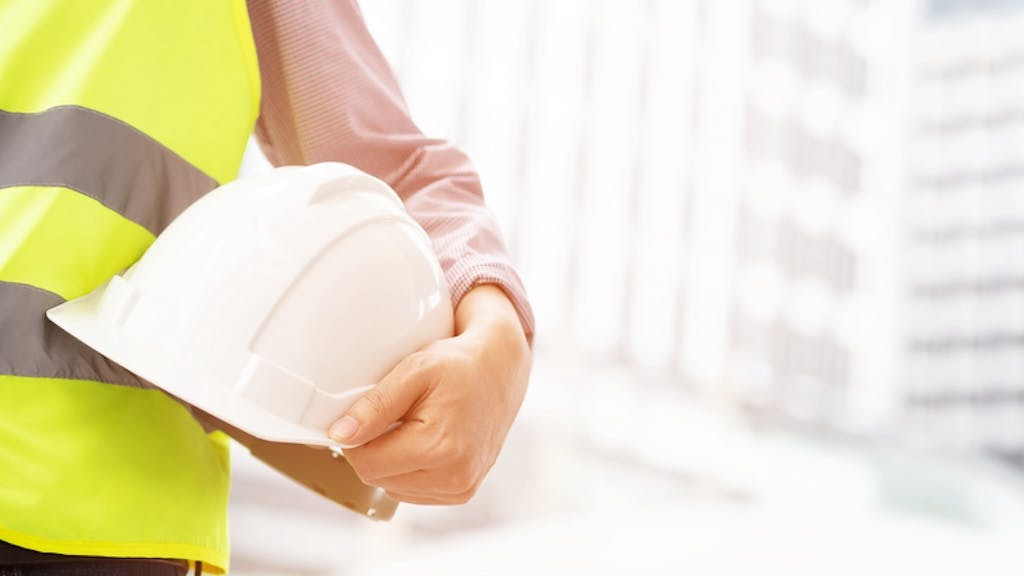 A construction worker with hard hat in hand