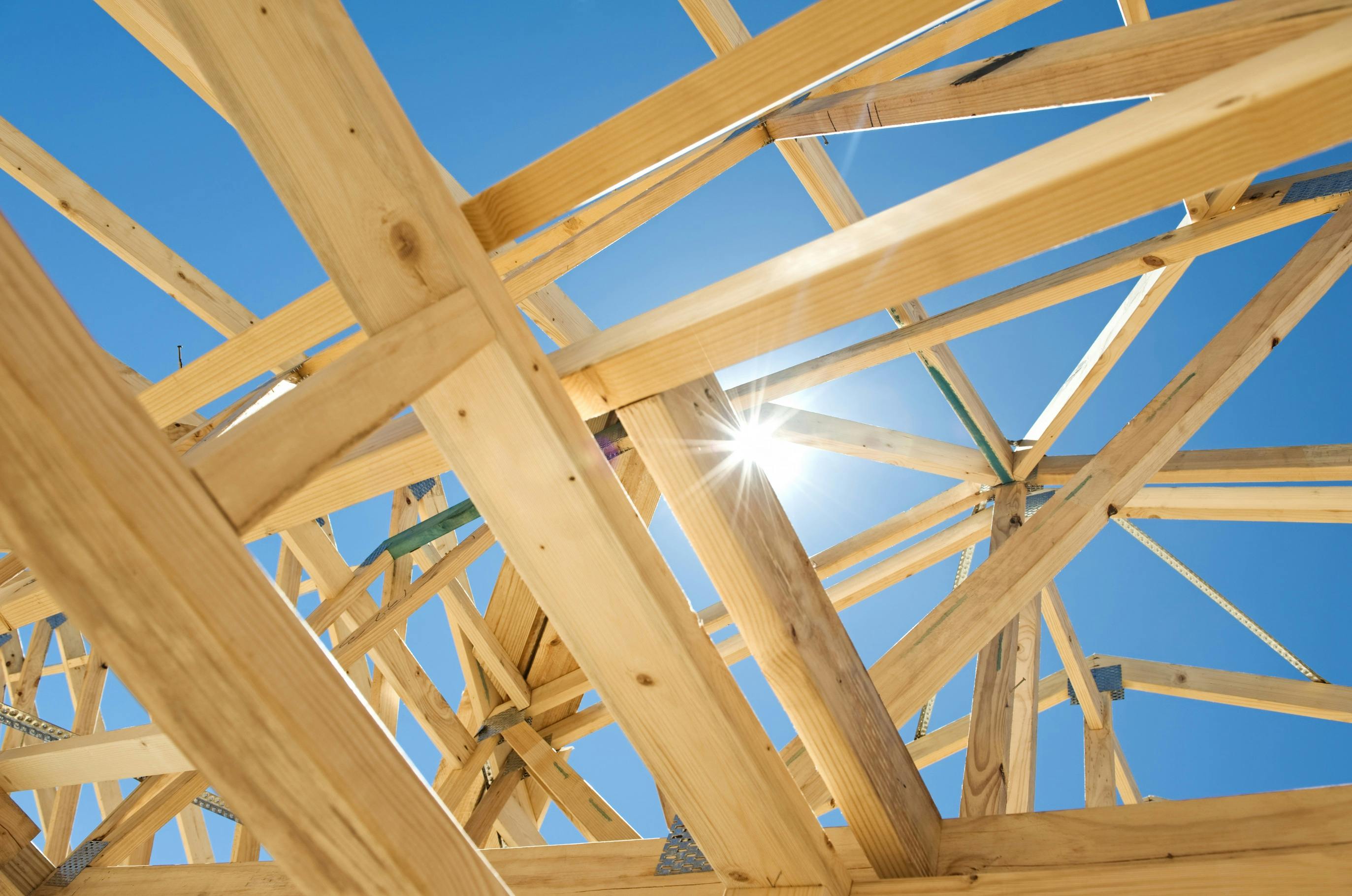 Abstract image of a home under construction, with the sky and sun peeking through