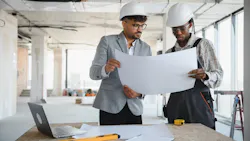 Builders look over house plan Builders look over house plan