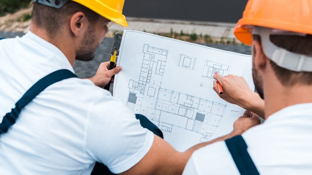 Two builders look over home floor plan together