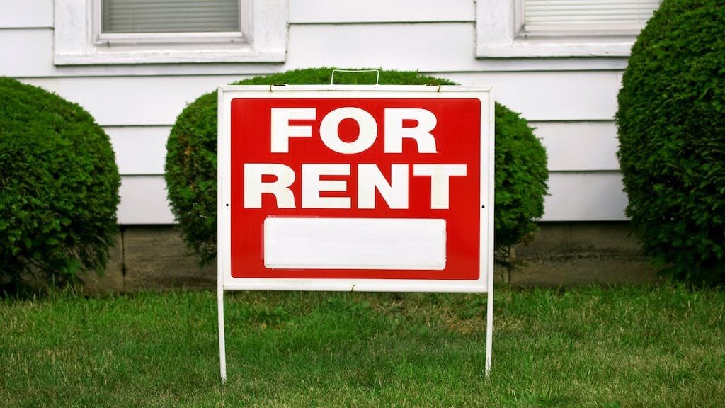 House with a 'For Rent' sign in the front yard