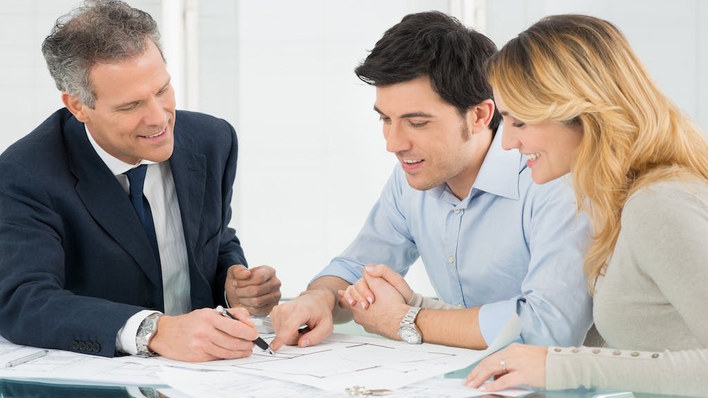 A real estate agent talks over options with a couple of homebuyers