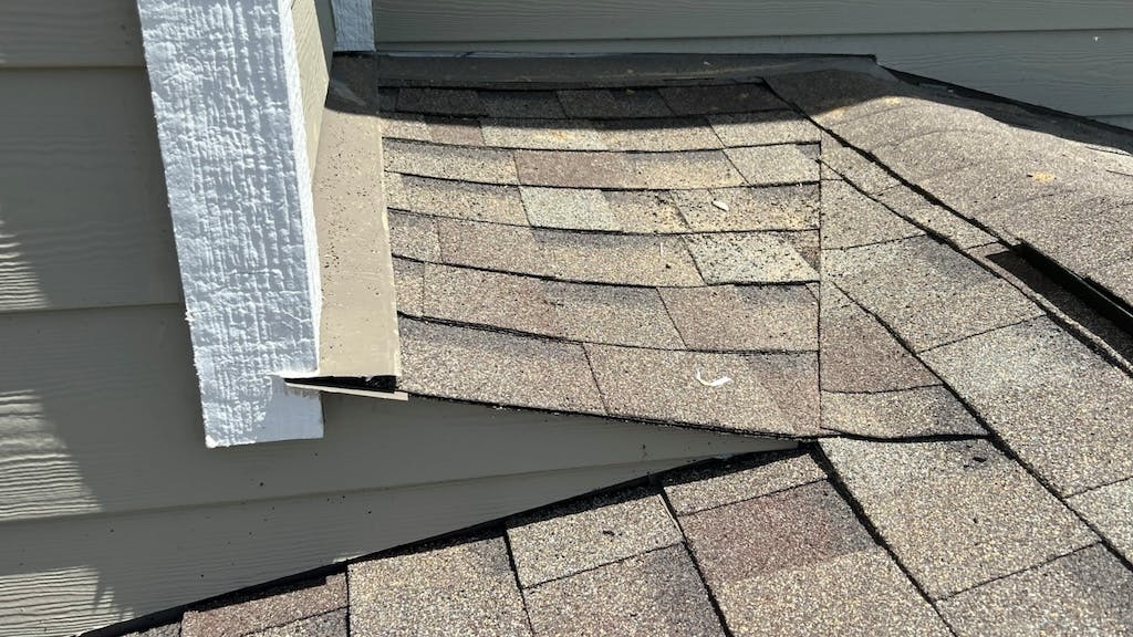 A properly formed cricket extends past the wall and directs water away from the roof-to-wall intersection