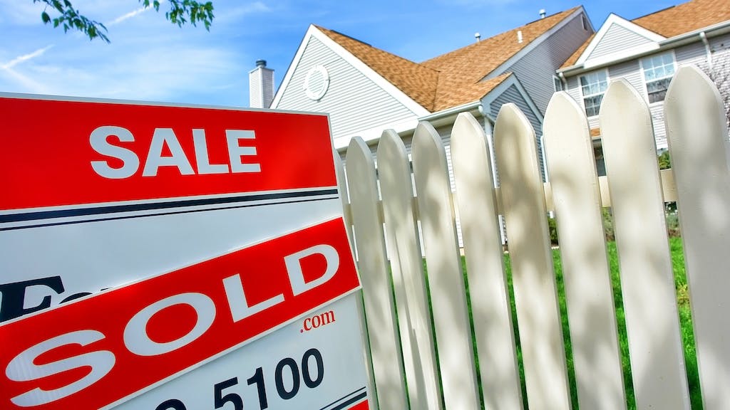 A 'sold' sign in front of a home