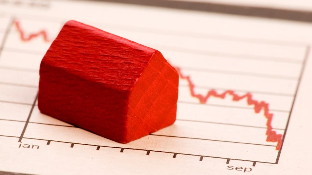 Model home sits on chart showing falling home prices