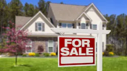 A red 'For Sale' sign in the front yard of a home A red 'For Sale' sign in the front yard of a home
