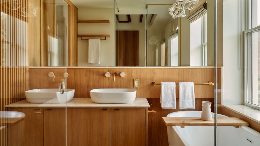 Bathroom showcasing flat-panel cabinets and wall-mounted faucets