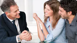 Real estate agent showing homebuyers the key to their new home Real estate agent showing homebuyers the key to their new home