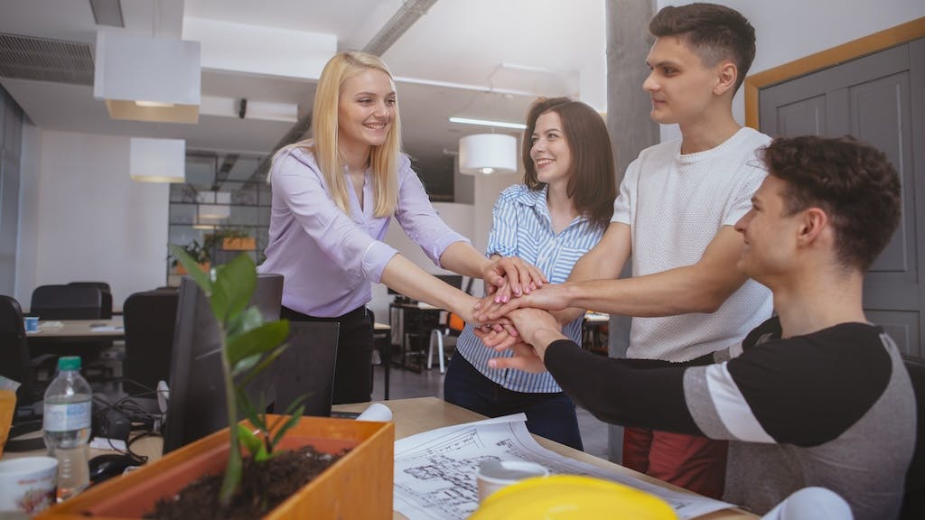 Residential construction team put their hands together, indicating they are on the same page