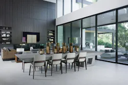 In the center of the great room, a dining table bridges the kitchen and the living room. The cantilevered table is bolted through the floor to a structural beam in the basement to create a unique and permanent focal point. Panels fronting the TV are speakers that separate to flank the screen. In the center of the great room, a dining table bridges the kitchen and the living room. The cantilevered table is bolted through the floor to a structural beam in the basement to create a unique and permanent focal point. Panels fronting the TV are speakers that separate to flank the screen.