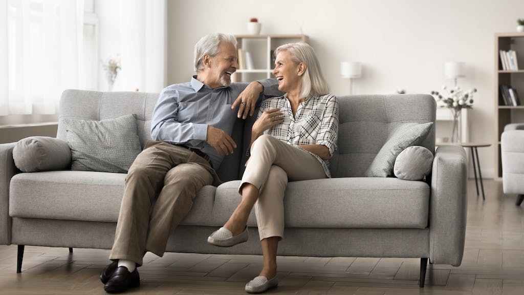 Older couple sitting on a couch in their home