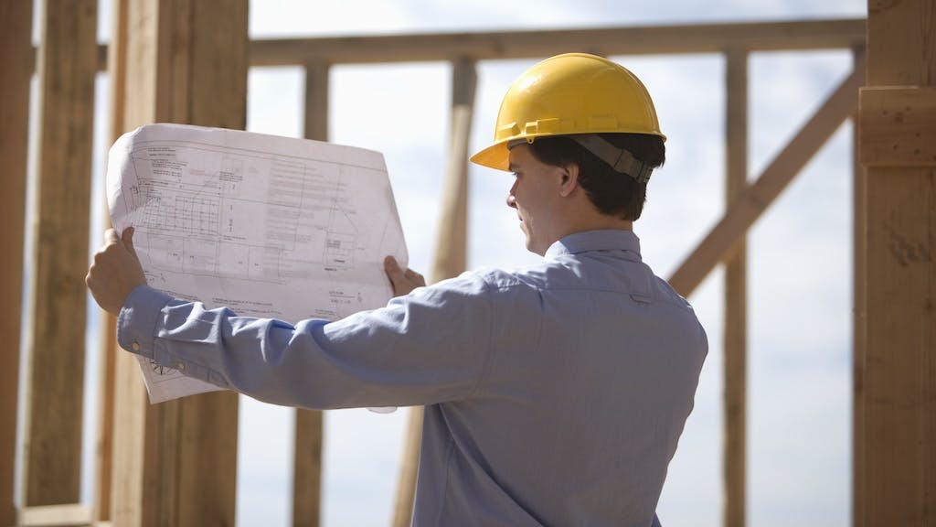 Home builder examining plans at a jobsite
