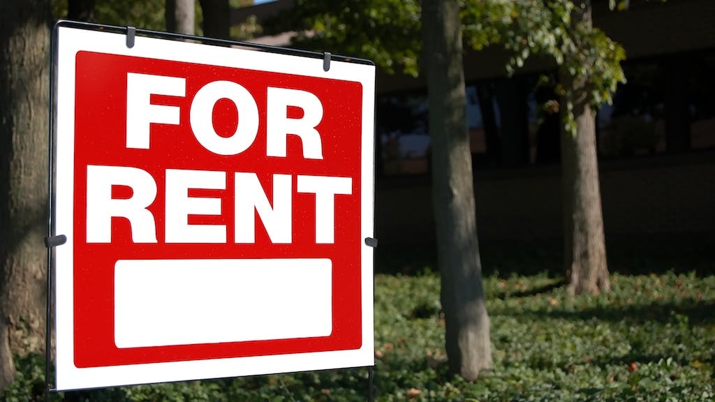 'For Rent' sign posted in a front yard