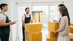 Movers bring boxes into a new home Movers bring boxes into a new home