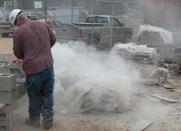 Construction worker cutting concrete block