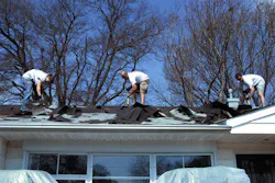 Men on residential roof remove asphalt shingles. Men on residential roof remove asphalt shingles.